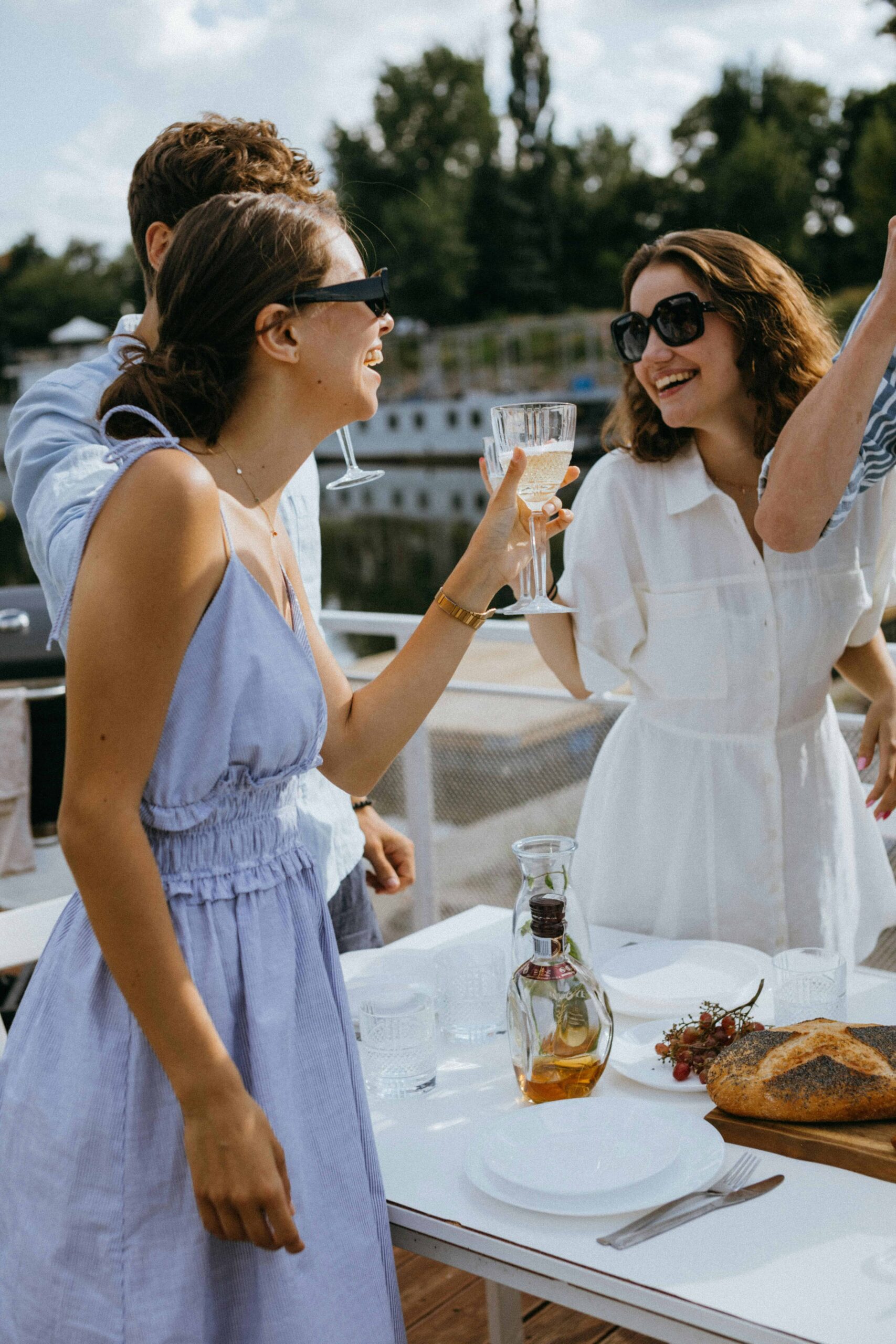 Friends in stylish summer outfits toasting with wine — ideal inspiration for Catalina Wine Mixer party outfits.